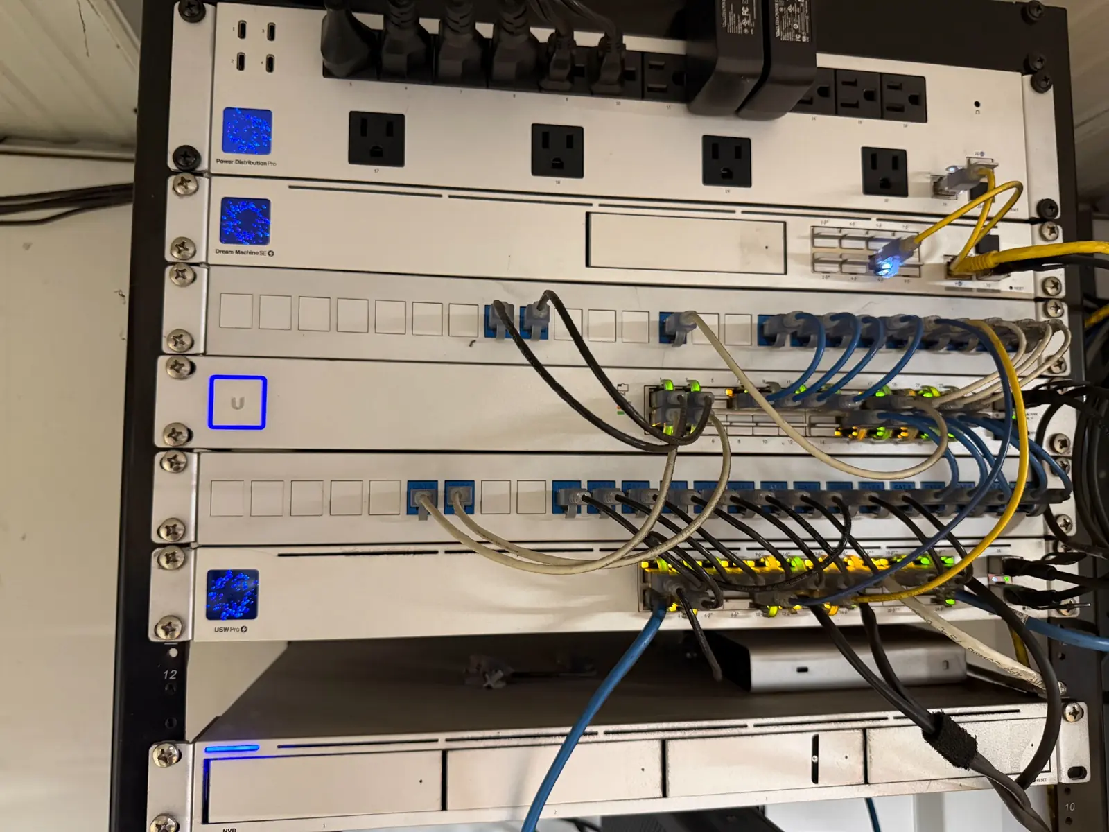 Commercial UniFi rack with gateway, switches, patch panels, and network video equipment